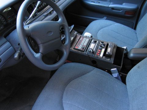 2001 Ford Crown Victoria - Interior view of a 2001 Ford Crown Victoria police car, equipped with a police radio and other communication devices.
