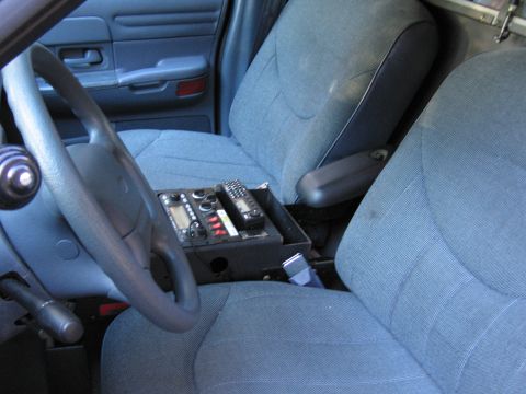 2001 Ford Crown Victoria - The interior of a 2001 Ford Crown Victoria police car, equipped with communication radios in the center console.