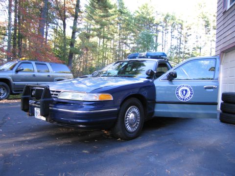 2001 Ford Crown Victoria - Massachusetts State Police Crown Victoria with its door open, parked in a driveway with an SUV nearby.