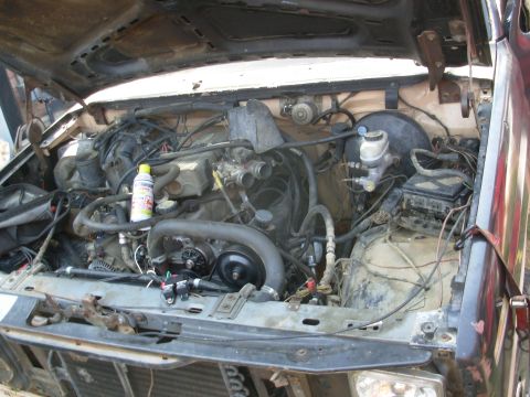 1983 Ford Bronco - Engine bay of a 1983 Ford Bronco, showing engine components and a spray can.