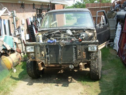 1983 Ford Bronco - This 1983 Ford Bronco is in a state of disassembly, with its front end exposed and the driver's door ajar.