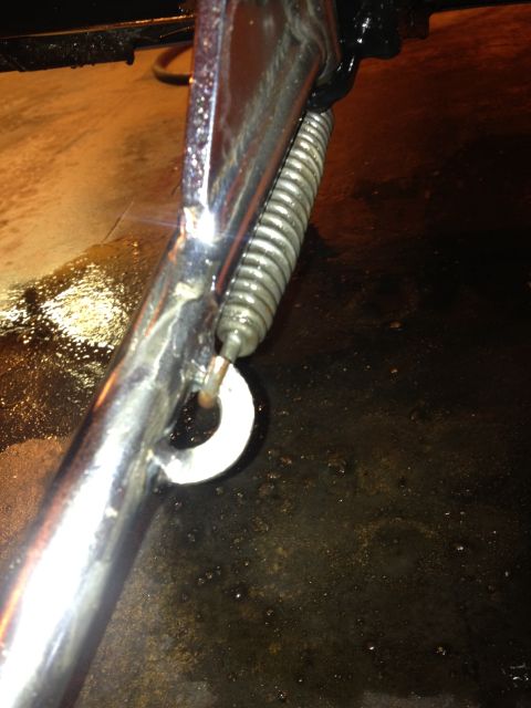 1995 Ford Bronco - Close-up of a motorcycle kickstand spring and its attachment point, showing a white washer.