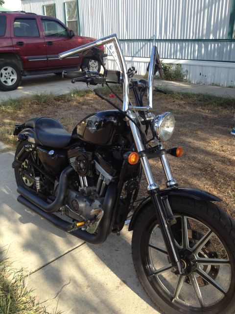 1995 Ford Bronco - Custom Harley-Davidson motorcycle with ape hanger handlebars parked outdoors.
