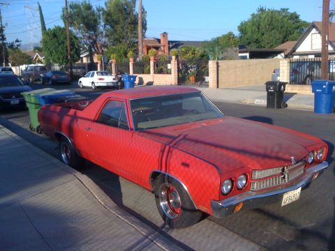 1968 Ford Mustang - A red El Camino is parked on the side of a residential street, with trash cans nearby.