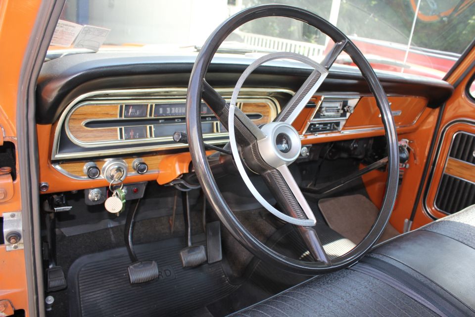 Interior shot of a truck's dashboard, showing the steering wheel, instrument cluster, and orange trim