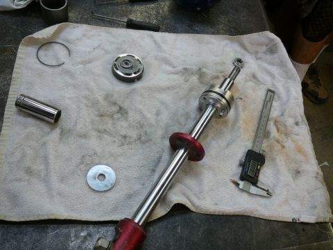 1988 Ford Bronco - Tools and parts laid out on a towel, including a disassembled shifter assembly and a digital caliper.