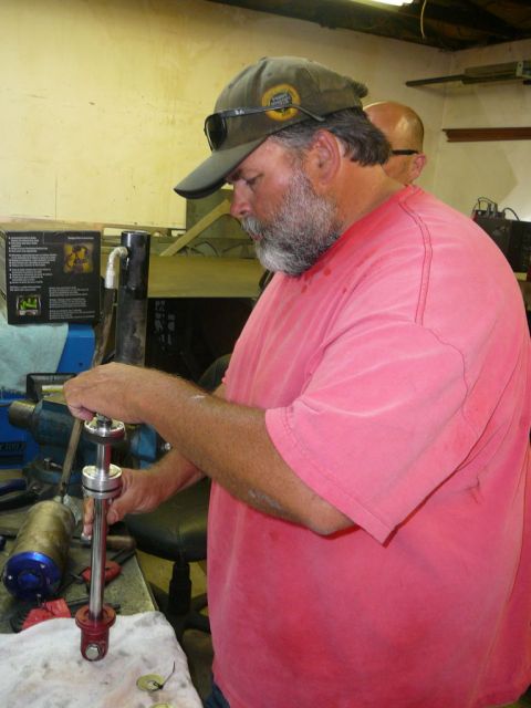 1988 Ford Bronco - A man is shown assembling a car part in a workshop setting.
