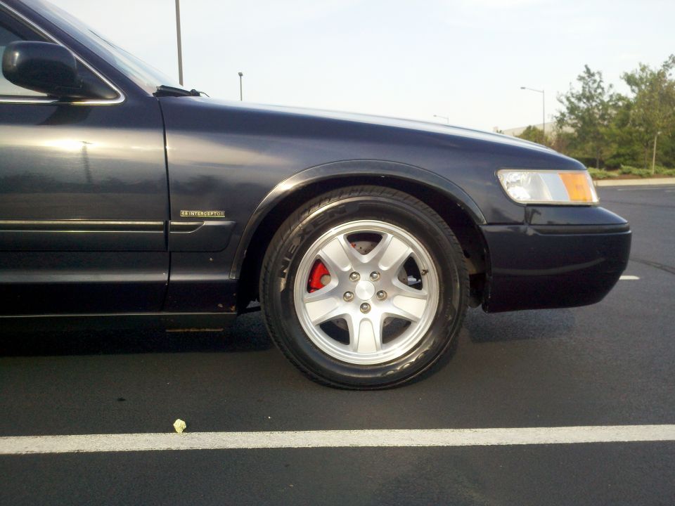 Silver five-spoke wheel and red caliper on blue Mercury with 4.6 Interceptor badge