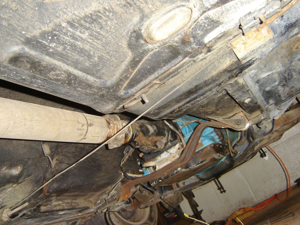 Underside view of vehicle drivetrain with driveshaft and transmission