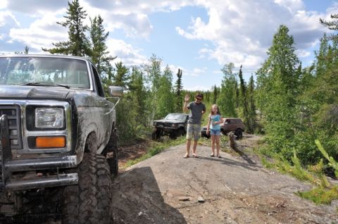 1986 Ford F-150 - Off-roading adventure with multiple Ford trucks and people enjoying the outdoors.