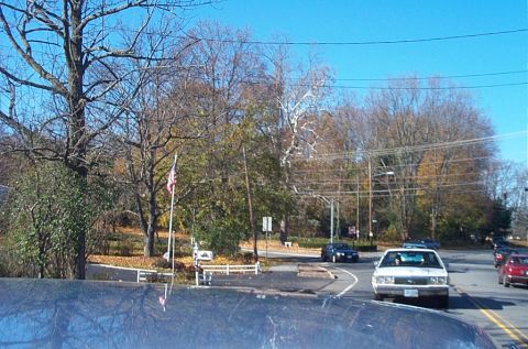 1991 Ford LTD Crown Victoria - A white sedan with a boxy 1980s body style drives on a road with other vehicles.