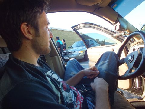 2003 Ford Crown Victoria - View from a tan-interior car of a man holding keys, with a silver Ford sedan parked outside.