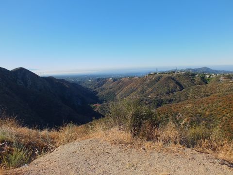 2003 Ford Crown Victoria - Dirt foreground at a mountain viewpoint over a green canyon and distant haze