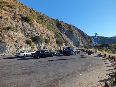 2003 Ford Crown Victoria - Row of Panther sedans at a hillside lot beside a Call Box sign and guardrail