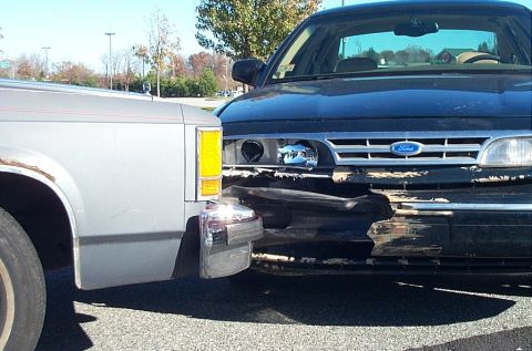 1991 Ford LTD Crown Victoria - A black 1991 Ford Crown Victoria shows significant damage to its front bumper and grille.