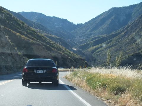 2003 Ford Crown Victoria - Following a black Ford full-size sedan down a winding two-lane canyon highway