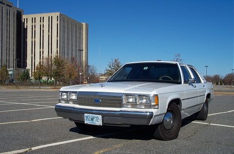 1991 Ford LTD Crown Victoria - This 1991 Ford Crown Victoria LTD is captured from a three-quarter front view in an empty parking lot.