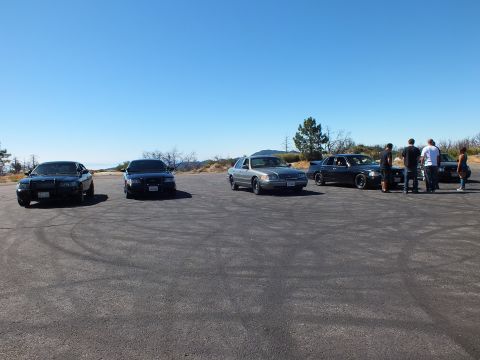 2003 Ford Crown Victoria - Four-door sedans line up on skid-marked pavement as a small group looks on.