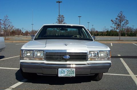 1991 Ford LTD Crown Victoria - Front view of a white Ford Crown Victoria sedan with a chrome grille and rectangular headlights.