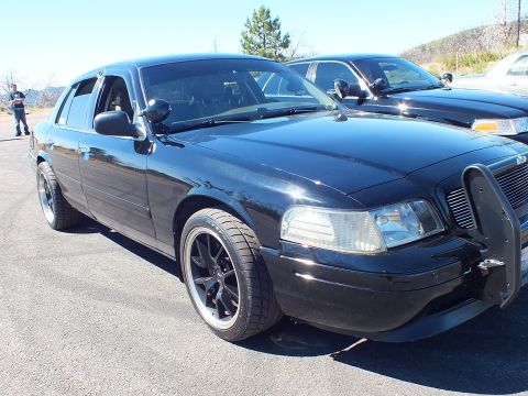 2003 Ford Crown Victoria - Side-front view of a lowered black full-size sedan with another car beside it