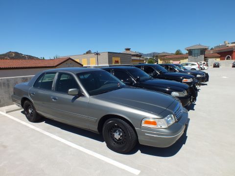 2003 Ford Crown Victoria - Silver Crown Victoria with black wheels parked alongside dark sedans on a rooftop deck