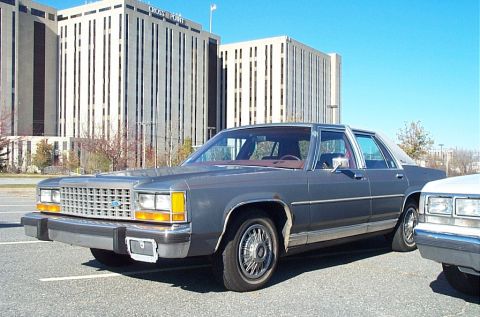 1991 Ford LTD Crown Victoria - A gray 1988 Ford Crown Victoria is parked in a lot with office buildings in the background.