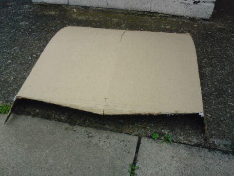 1989 Ford Bronco - A piece of cardboard lies on a concrete surface, marked with a Supermotors watermark.