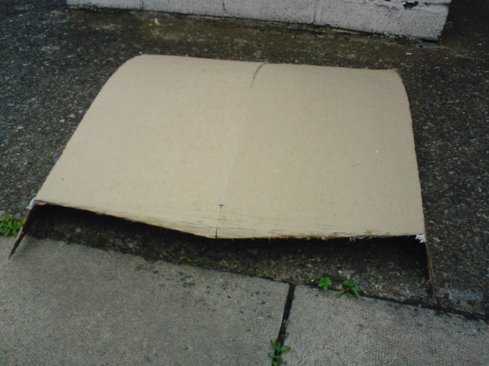 Cardboard piece on concrete with a Supermotors watermark