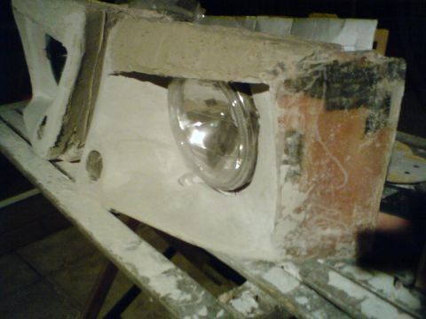 1989 Ford Bronco - This is a close-up view of a vehicle's headlight assembly, showing the lens and surrounding structure.