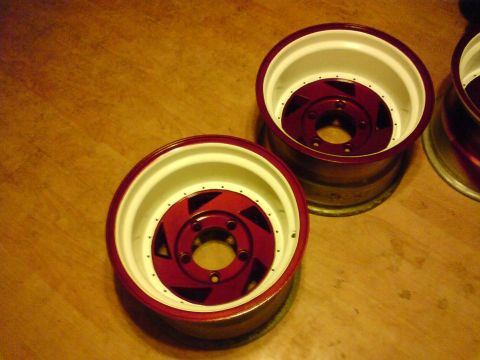 1989 Ford Bronco - Custom wheels with red centers and white rims are displayed on a wood surface.