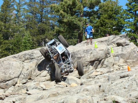 1989 Ford Bronco - Custom off-road buggy navigates a challenging rock crawling course with spectators observing.