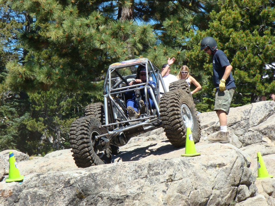 Off-road buggy with roll cage navigating rocky terrain