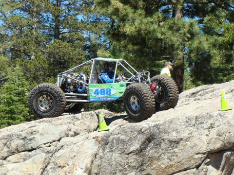 1989 Ford Bronco - A custom-built off-road buggy navigates a rocky terrain during an event.