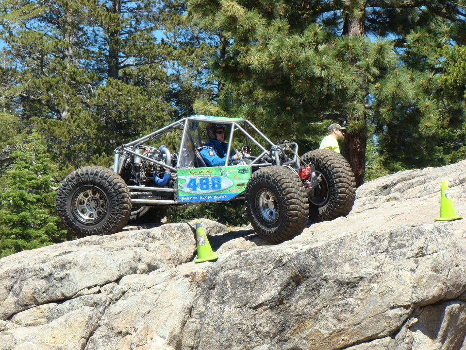 Off-road buggy with number 488 on the side climbing over rocks