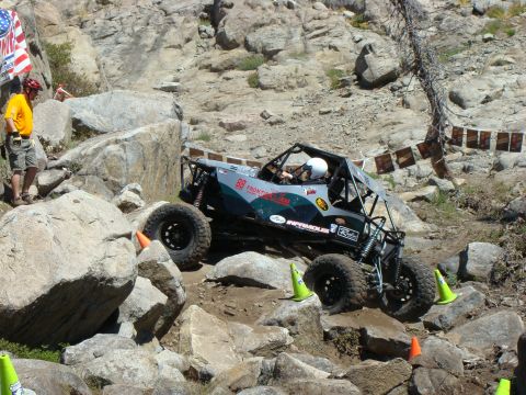 1989 Ford Bronco - Custom off-road buggy tackles a challenging rocky course with a spectator watching.