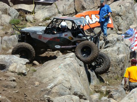 1989 Ford Bronco - A custom-built off-road buggy navigates a challenging rocky terrain during a competition.