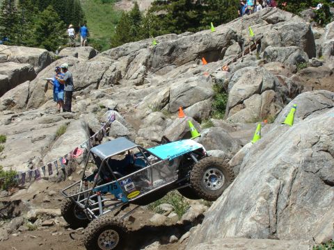 1989 Ford Bronco - Custom off-road buggy navigates a challenging rocky course with spectators watching.
