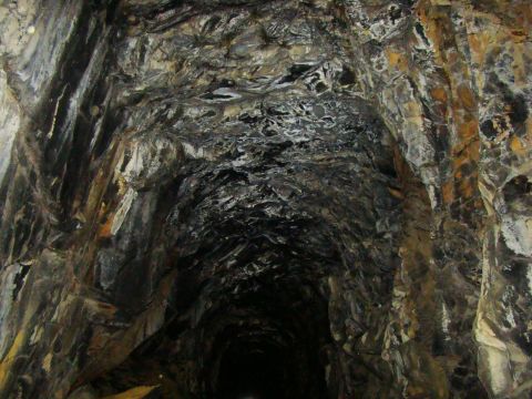 1989 Ford Bronco - Interior view of a mine tunnel, showing the rough, natural rock formations of the walls and ceiling.