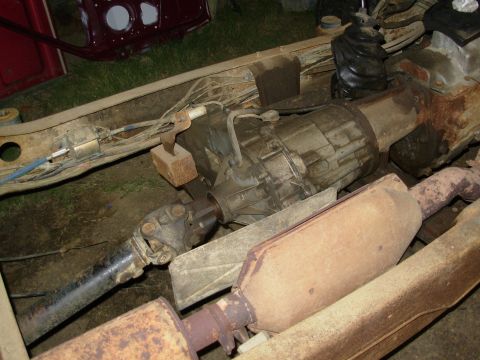 1983 Ford Bronco - Underside view of a vehicle's transfer case, driveshaft, and exhaust system.