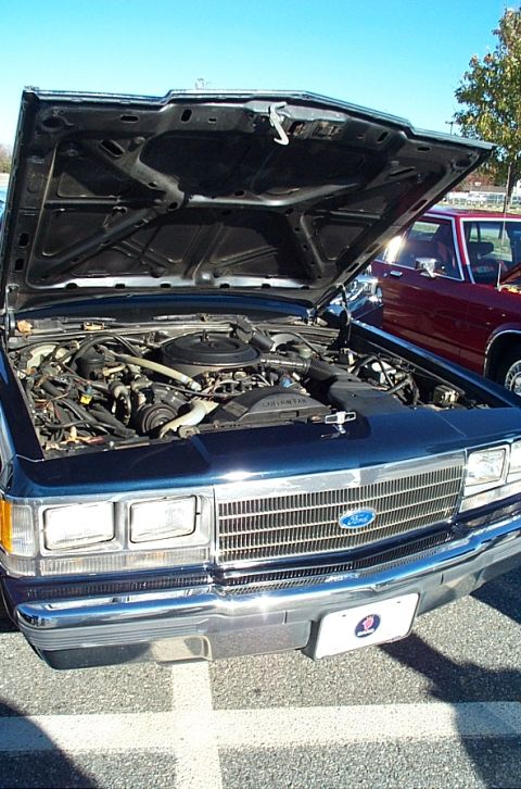 1991 Ford LTD Crown Victoria - Front view of a 1991 Ford Crown Victoria LTD with its hood open, revealing the engine bay.