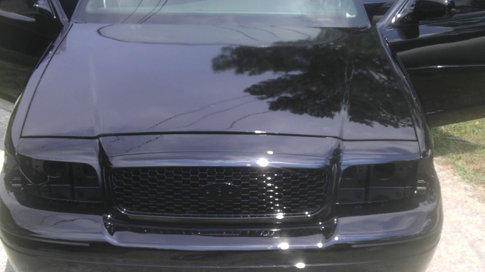 Black 2004 Ford Crown Victoria front end with honeycomb grille and tinted headlights