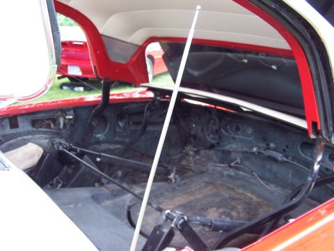 1975 Ford Ranchero - The interior of a red and white vehicle is shown with its hood open. A second red vehicle is visible in the background.