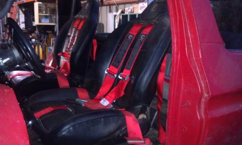 1978 Ford Bronco - Interior view of a vehicle with racing seats and harnesses.