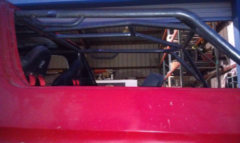 1978 Ford Bronco - Interior view of a vehicle with a custom roll cage and racing seats.