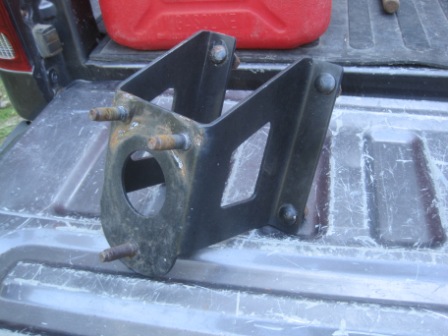 1993 Ford Bronco - Metal bracket with bolts, likely a vehicle part, on a truck bed.