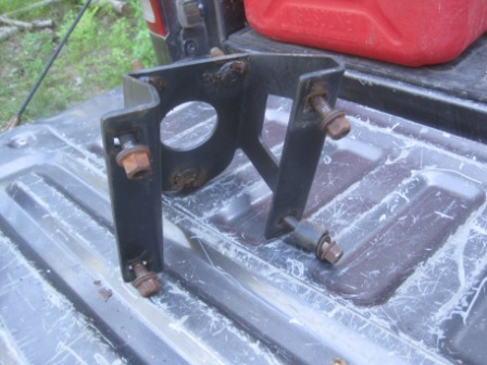 1993 Ford Bronco - A rusty metal bracket is shown resting on a truck bed, with a red gas can in the background.