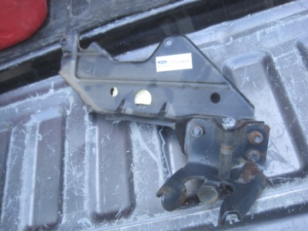 1993 Ford Bronco - A close-up view of a metal bracket, possibly a vehicle part, situated in the bed of a truck.