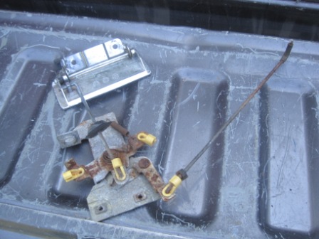 1993 Ford Bronco - A tailgate latch mechanism and handle are shown resting in a truck bed. The registry claims it is from a 1993 Ford Bronco, but this is unco…