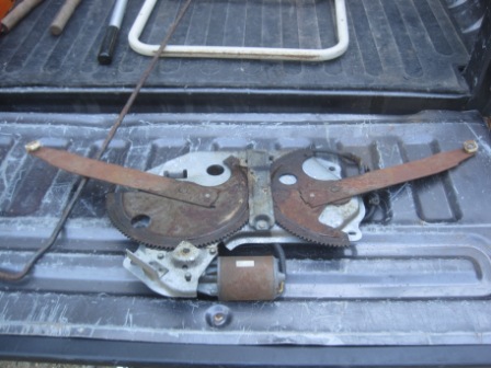 1993 Ford Bronco - A window regulator mechanism, likely for a vehicle door, is shown with its mechanical components and motor.
