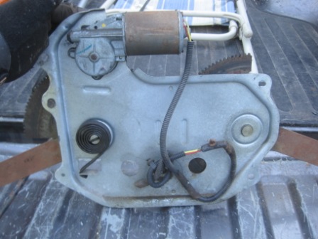 1993 Ford Bronco - Power window regulator assembly with motor and spring, likely for a car door.
